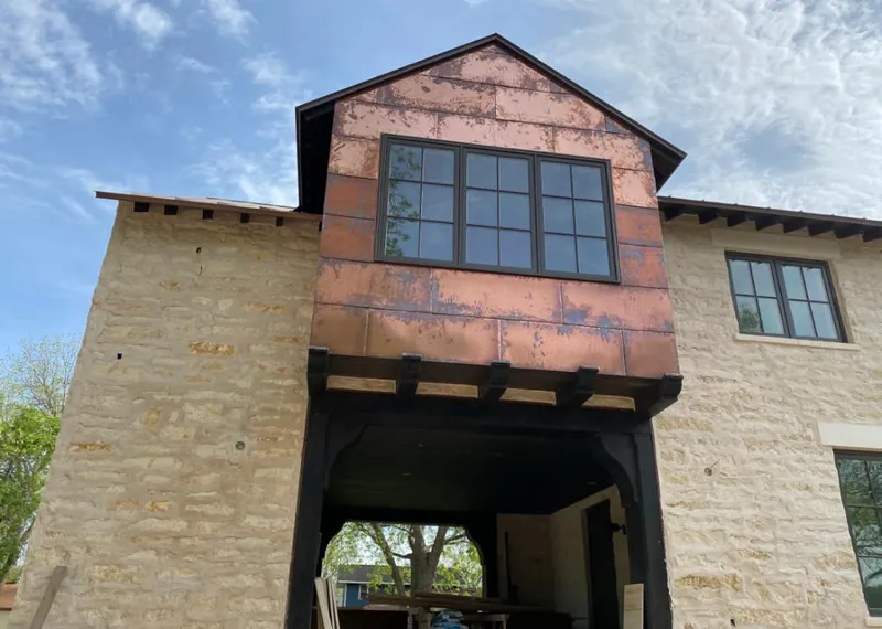Copper metal panel facade on a stone building for Roof Repair in Gilmer